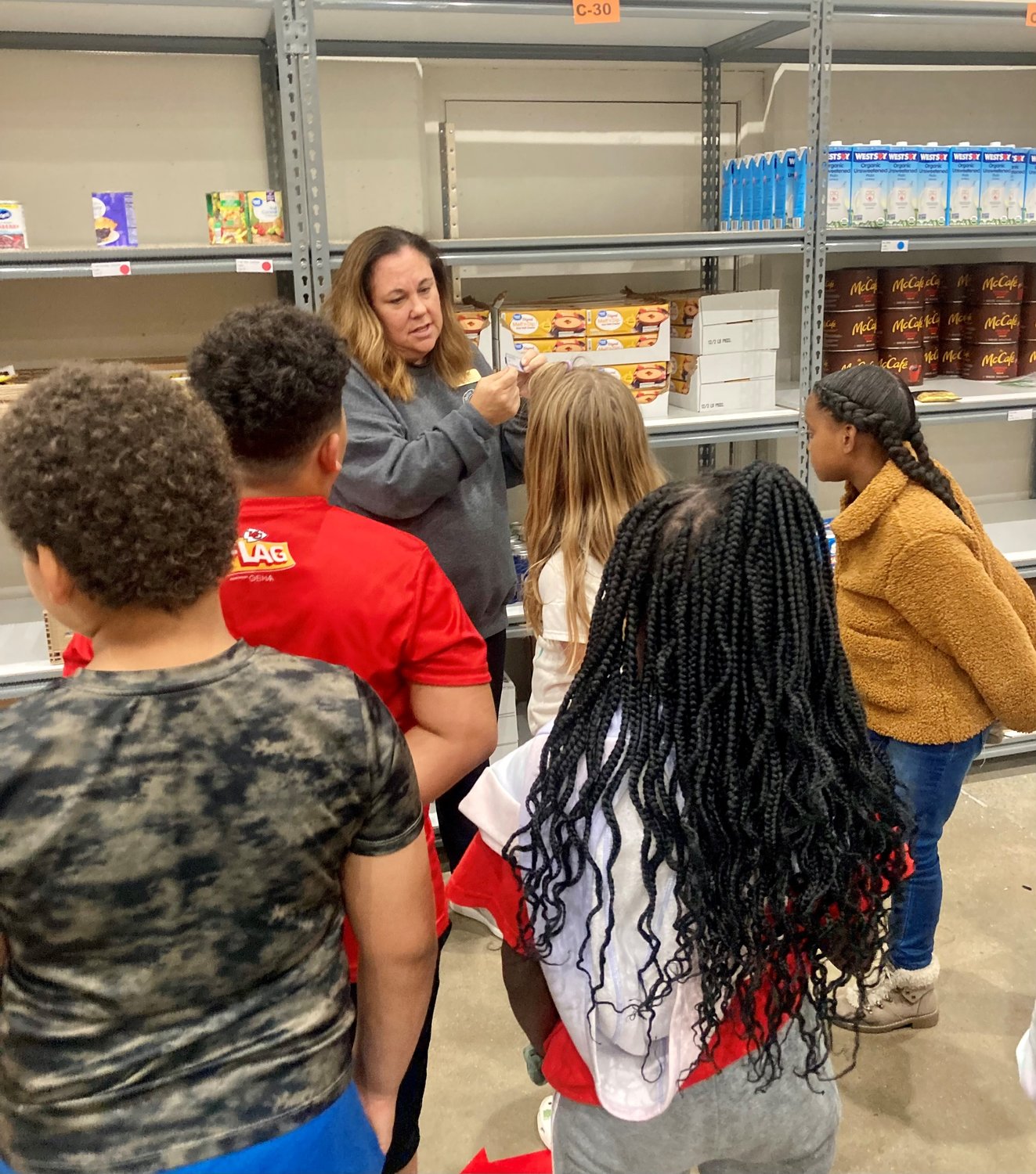 Members of the Boys & Girls Torch Club help out in the food pantry during a visit to the Catholic Charities Center in Jefferson City.